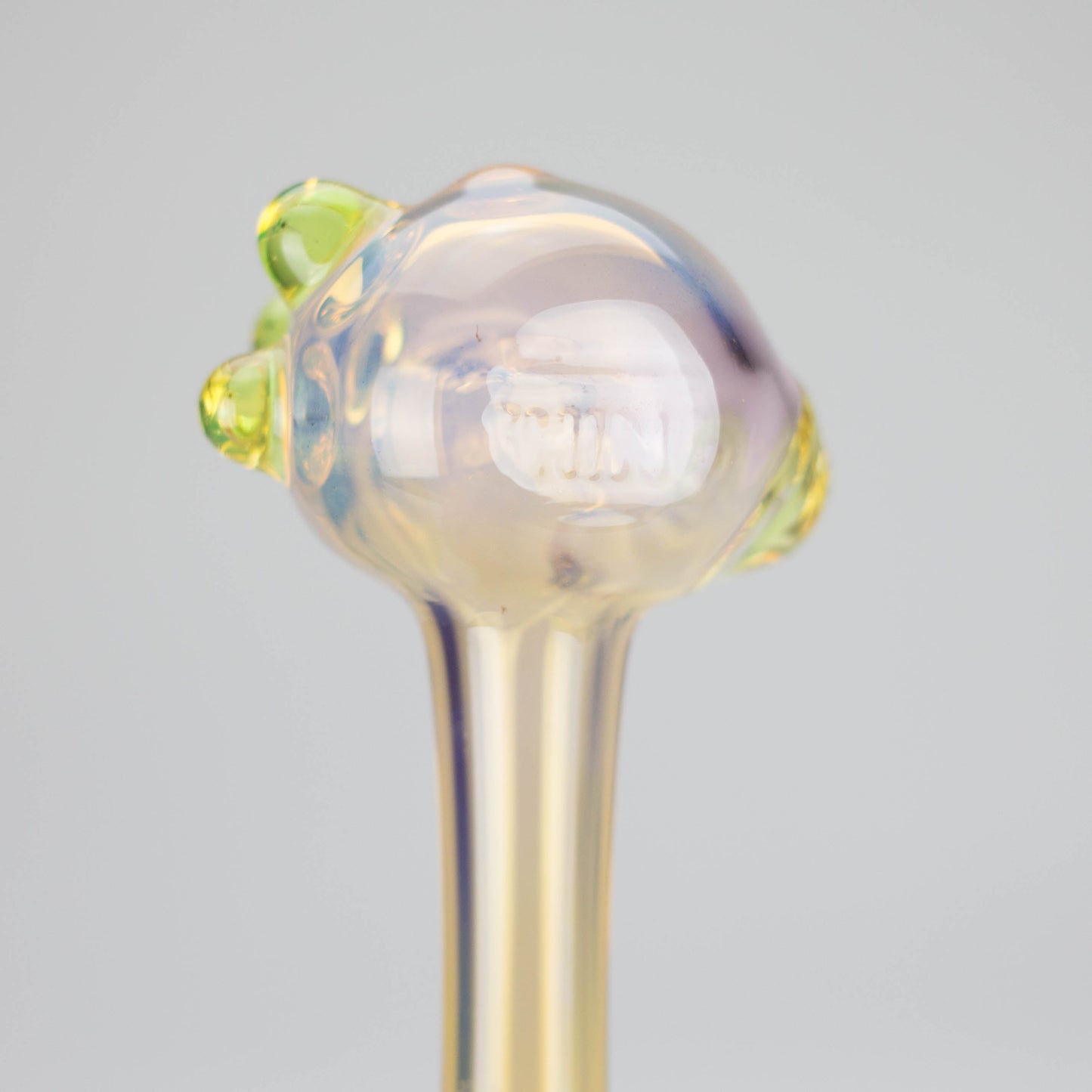 a translucent yellowish smoking pipe close up of the back